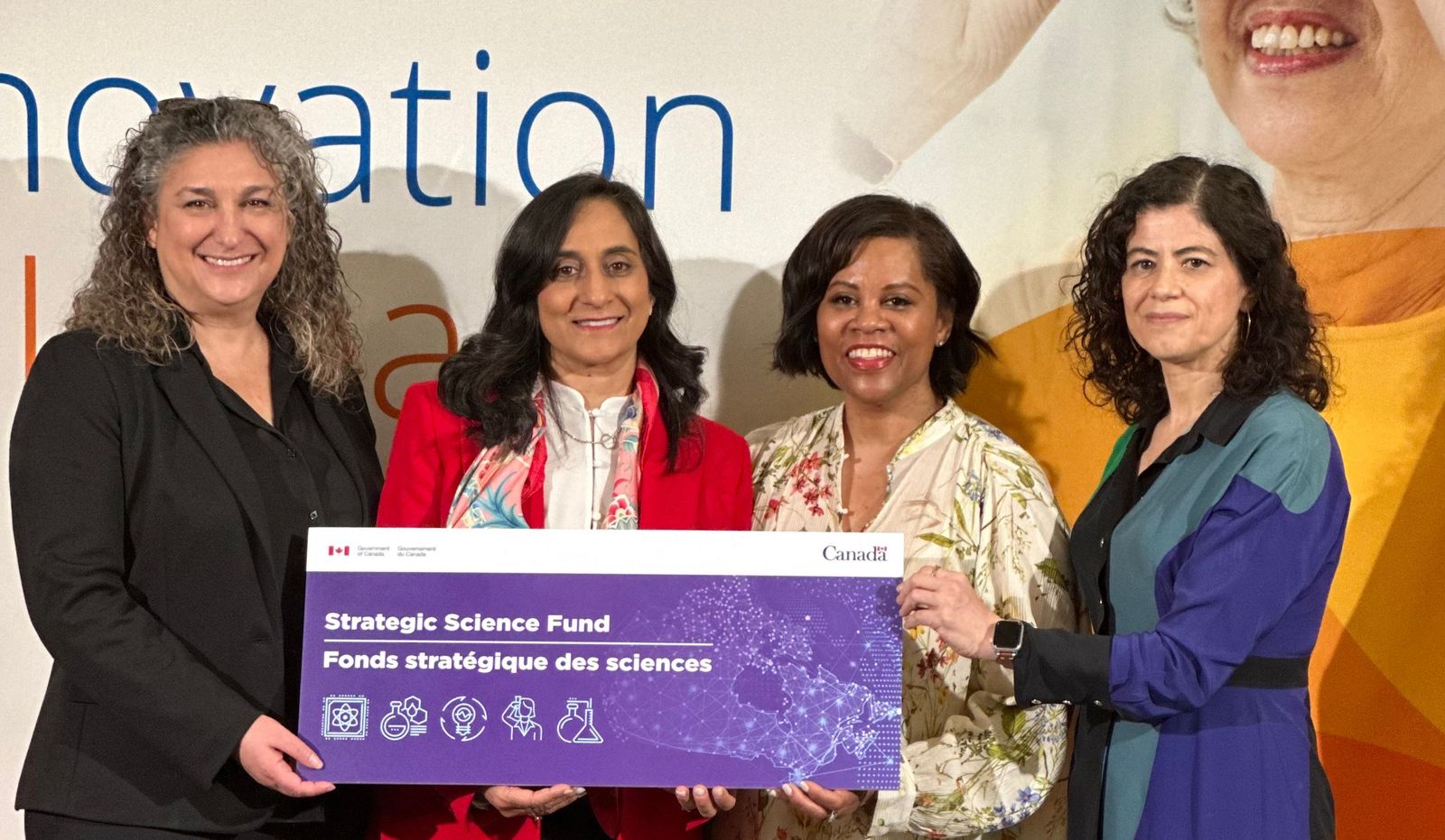 Four women holding a banner